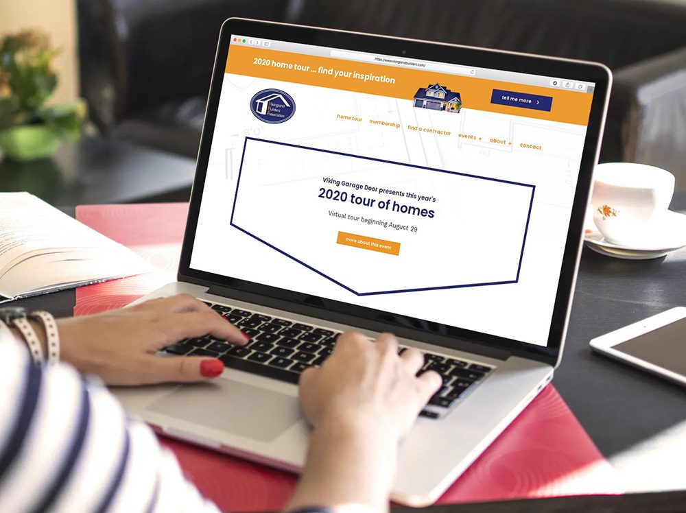 A laptop and smartphone showcase a real estate website for the Vikingland Builders Association. The site promotes the 