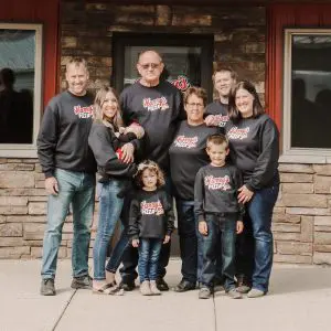 the zenzen family with Harry's pizza in front of the business