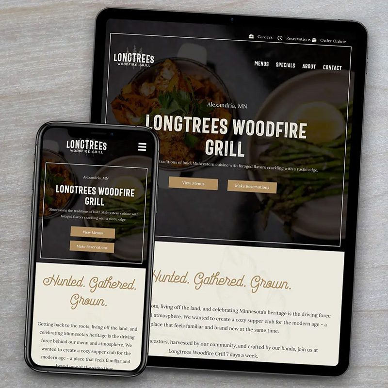 A tablet and a smartphone display the website for Longtrees Woodfire Grill. The screen shows a rustic-themed design with images of grilled food. The text includes the restaurant's name, location (Alexandria, MN), and options for reservations and online orders.